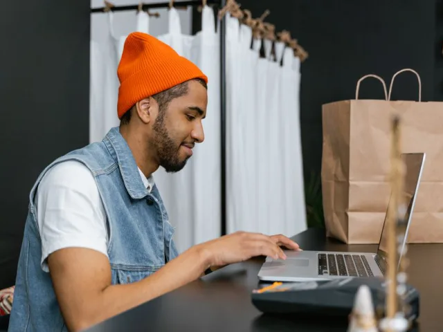 Vendedor trabalhando no notebook dentro da própria loja